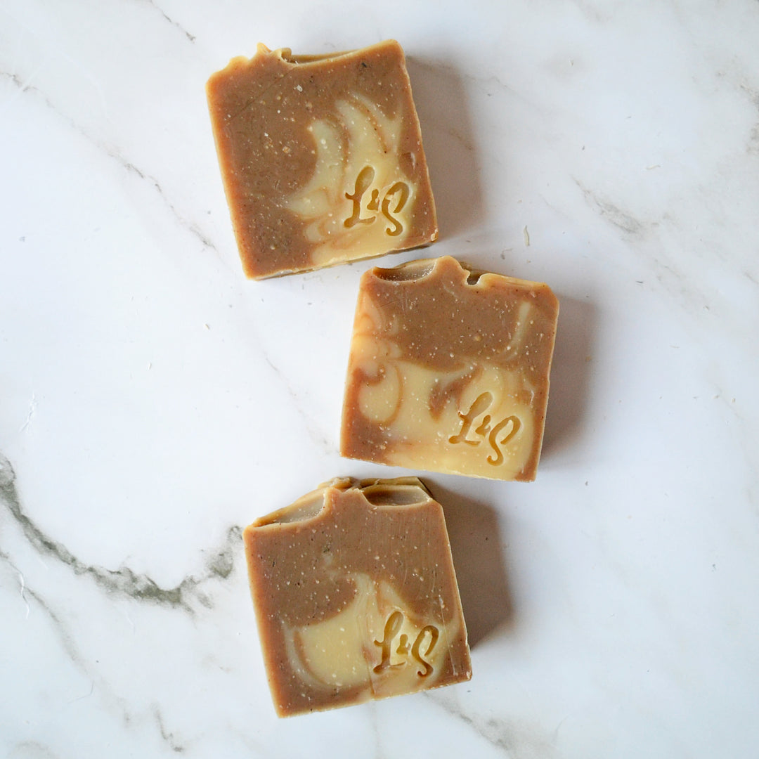 three bars of handmade matcha green tea soap on a white marble background