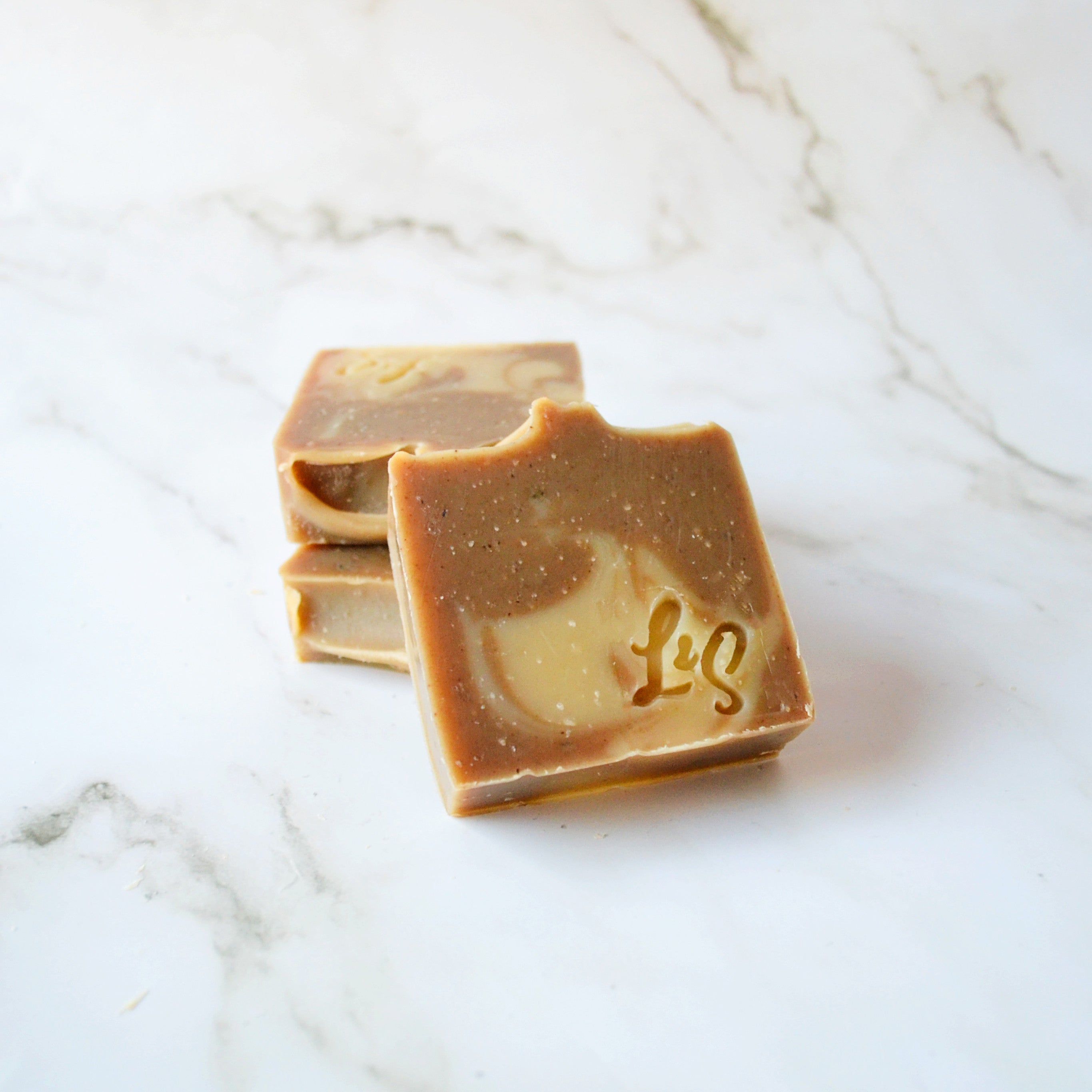 three bars of handmade matcha green tea soap on a white marble background