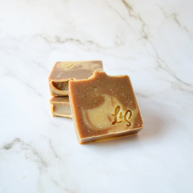 three bars of handmade matcha green tea soap on a white marble background
